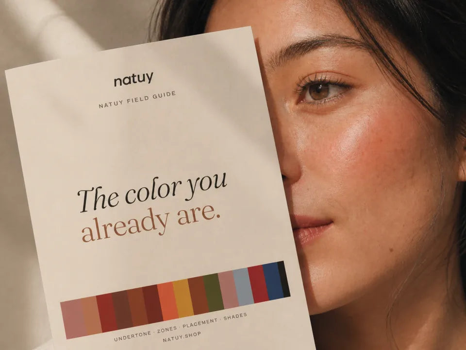 the natuy field guide held beside natural skin in warm daylight