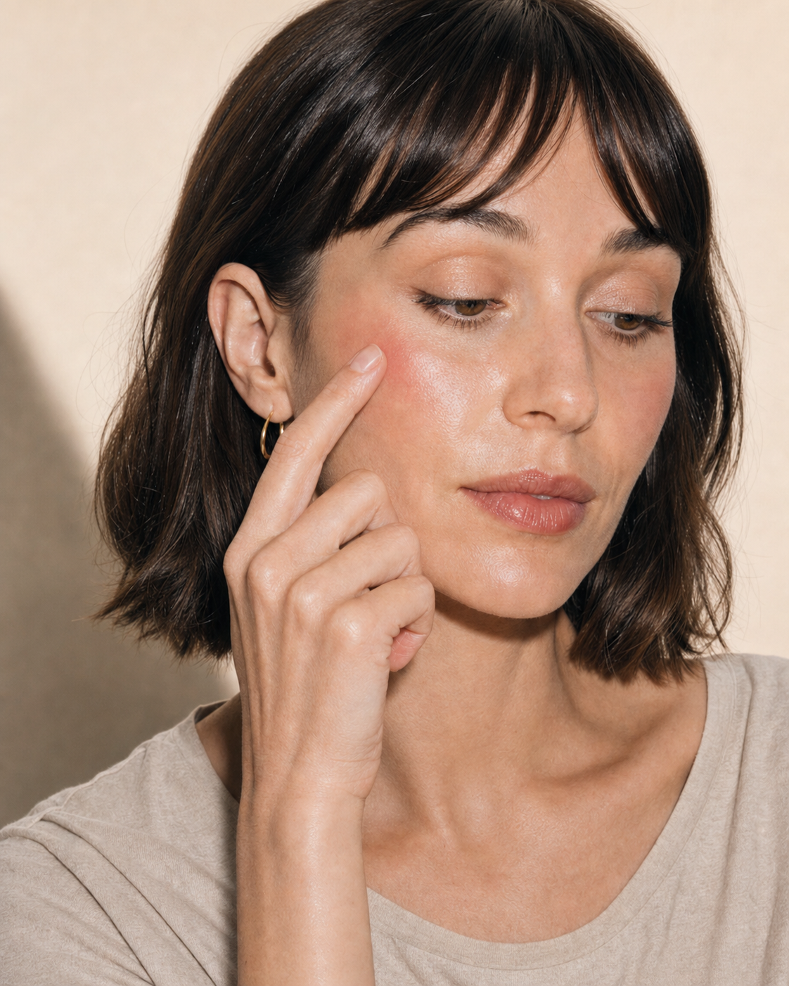 Mousse Blush being blended with a fingertip